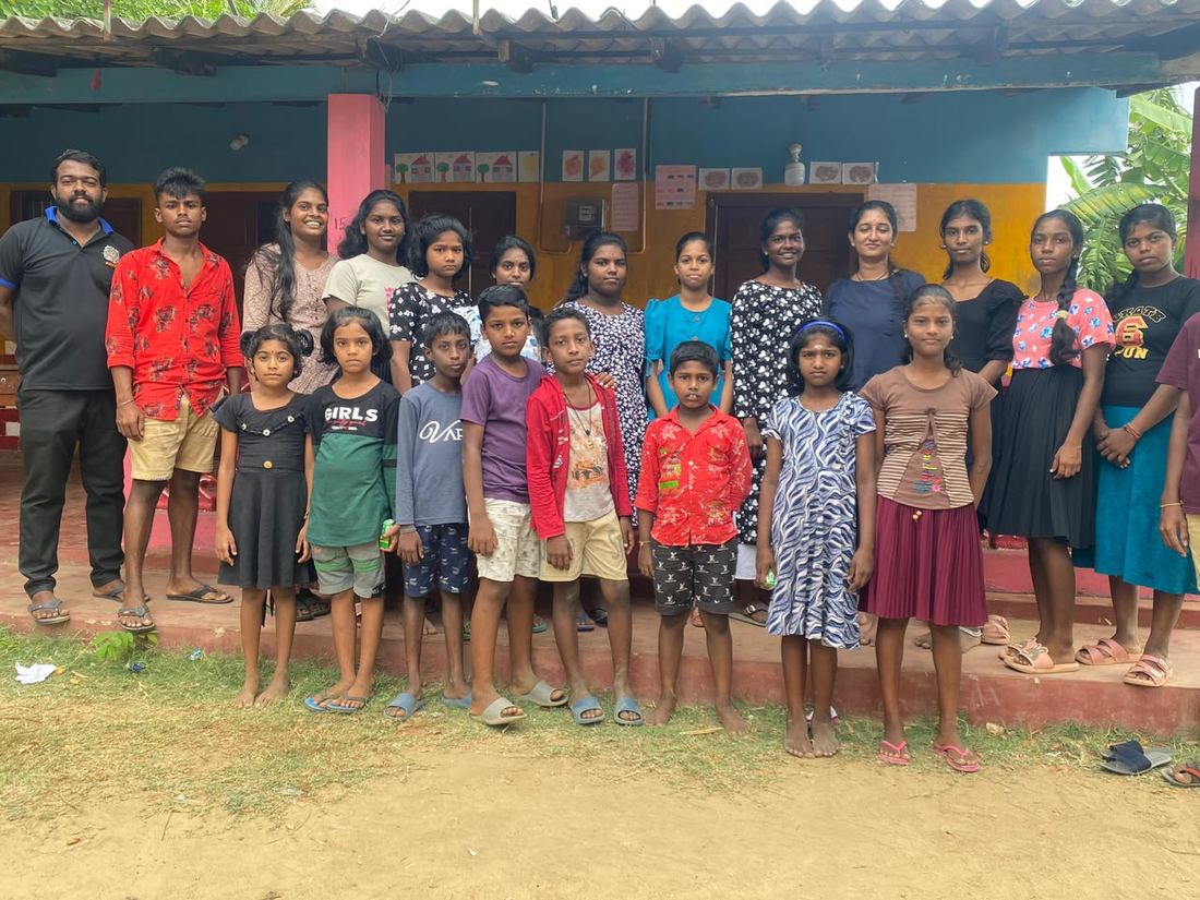 Group photo of children and CPYE staff at a resettlement community